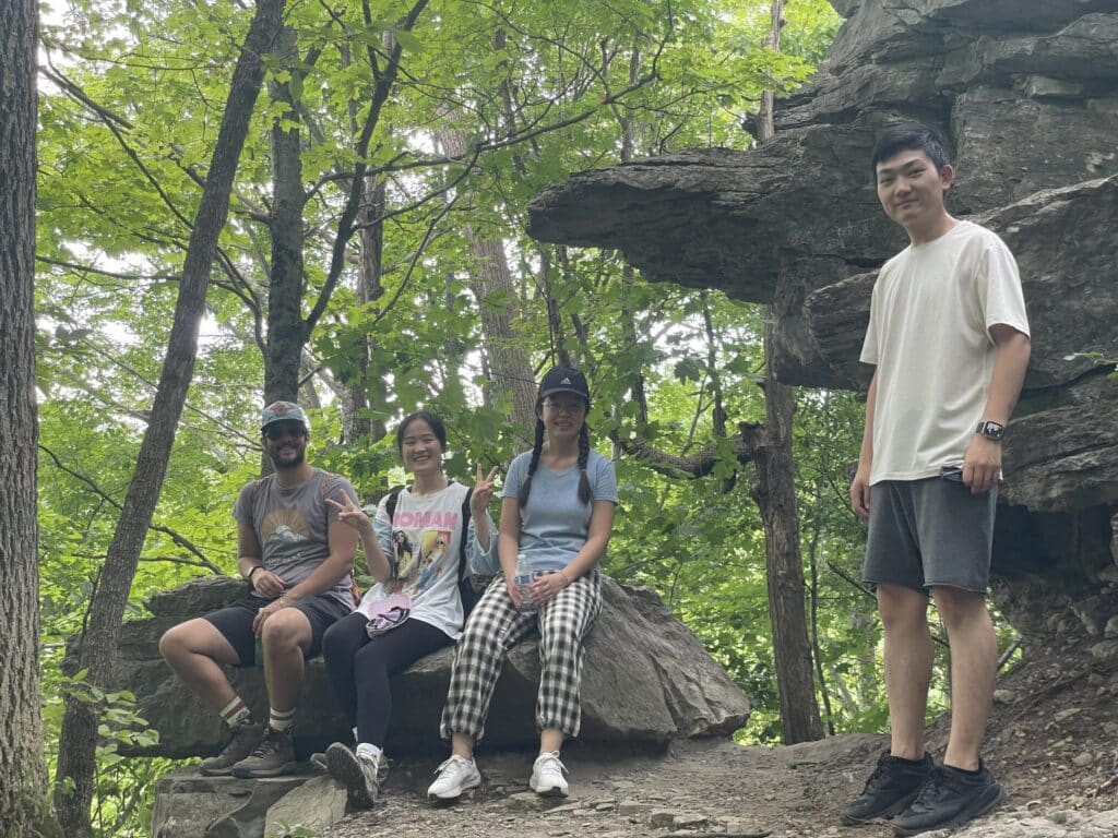 Lab members sitting on a boulder at Clark Reservation State Park