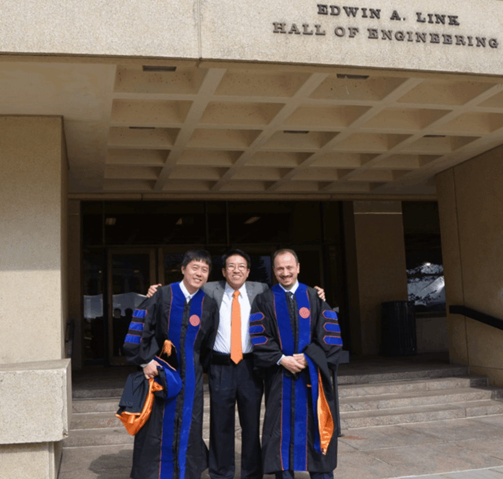 Dr. Ren and two lab members with graduate regalia pose after commencement in 2016