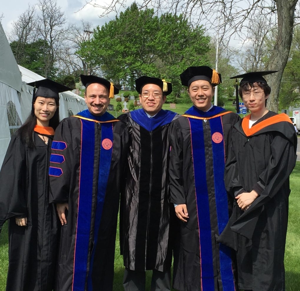 Dr. Ren and four lab members with graduate regalia pose after commencement in 2016