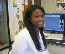 Shanelle Simone Gayle sitting next to a computer